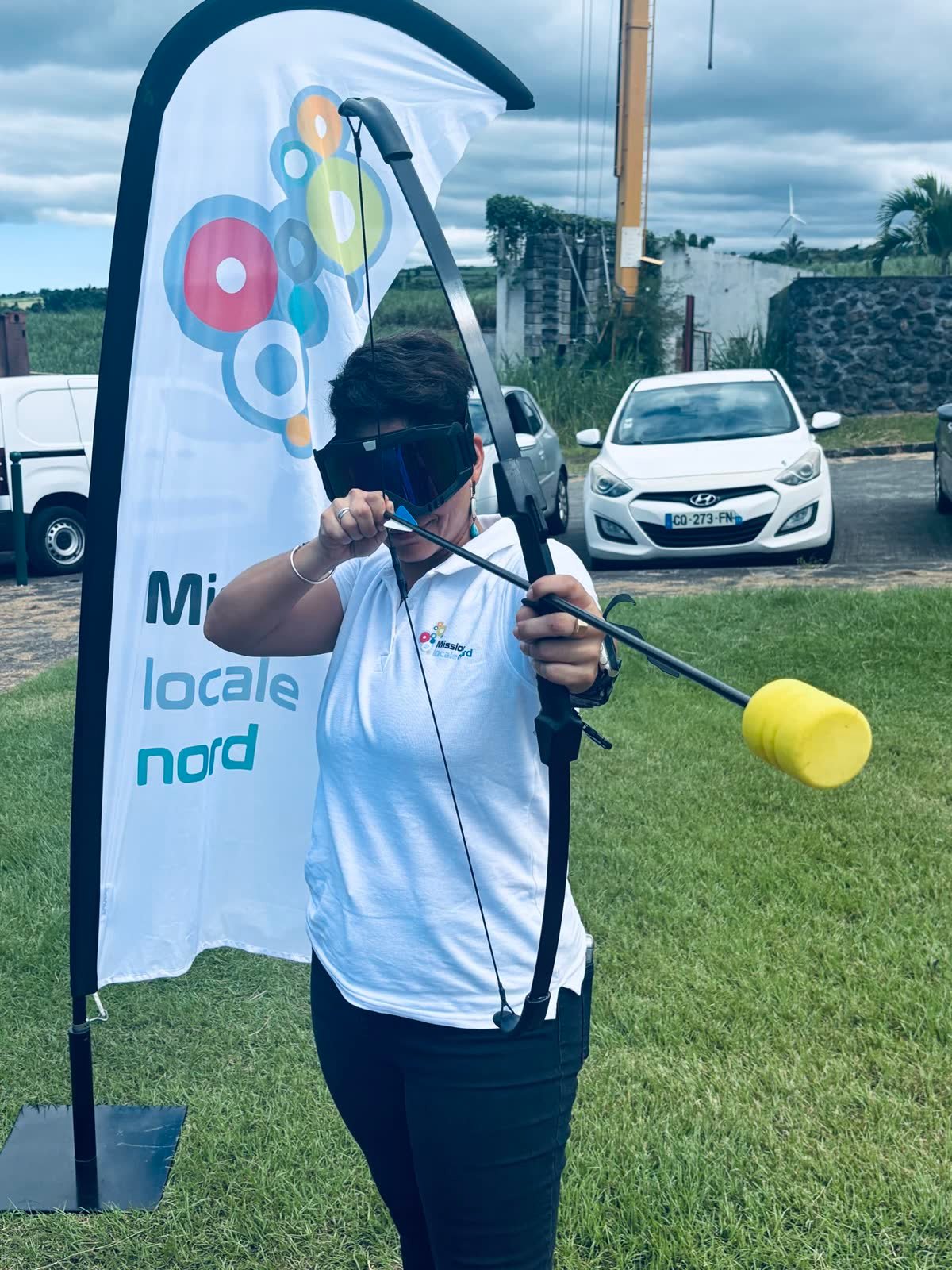 Participante d'archery tag visant avec un arc lors d'un team building 974