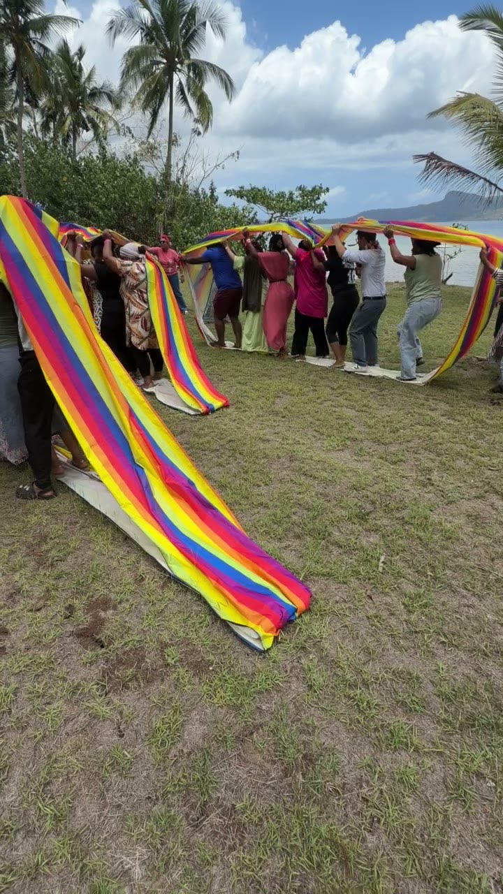 Parachute géant multicolore manipulé par une équipe lors du team building Pull Up à Mayotte