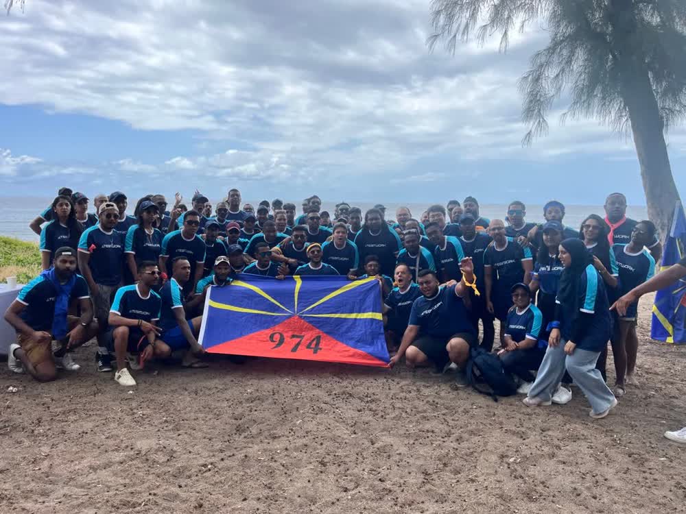 Groupe d'entreprise en team building sur une plage de La Réunion avec le drapeau 974