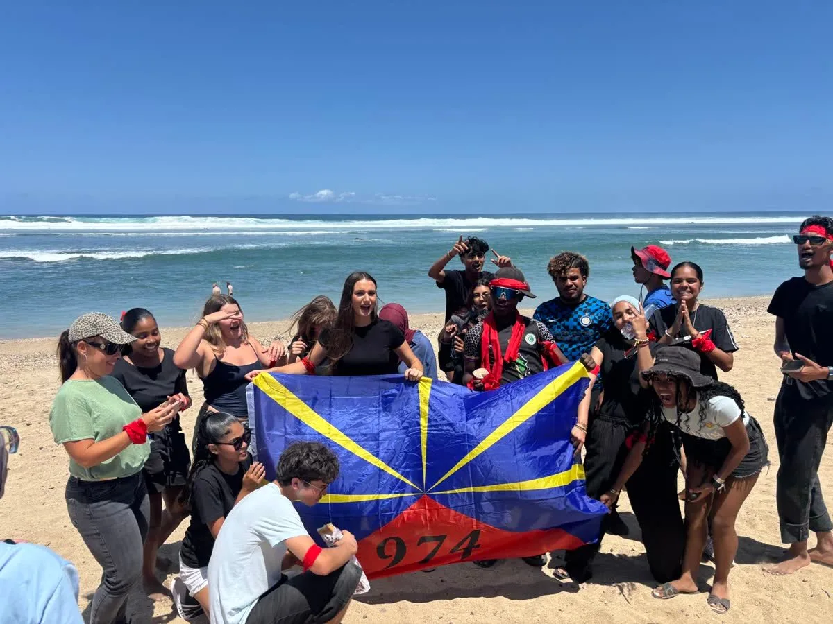Photo de groupe avec drapeau de La Réunion sur la plage après un team building